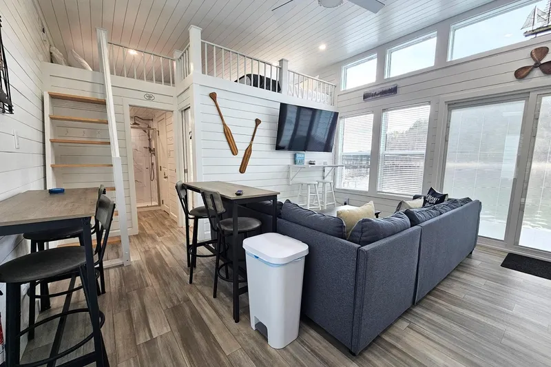 Slide: The Image of Modern 2025 houseboat interior with loft, cozy seating, and large windows overlooking water. - 4