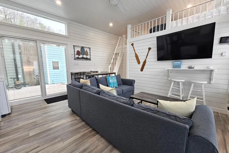 Slide: The Image of Modern 2025 houseboat interior with cozy seating, large TV, and stylish decor. - 5