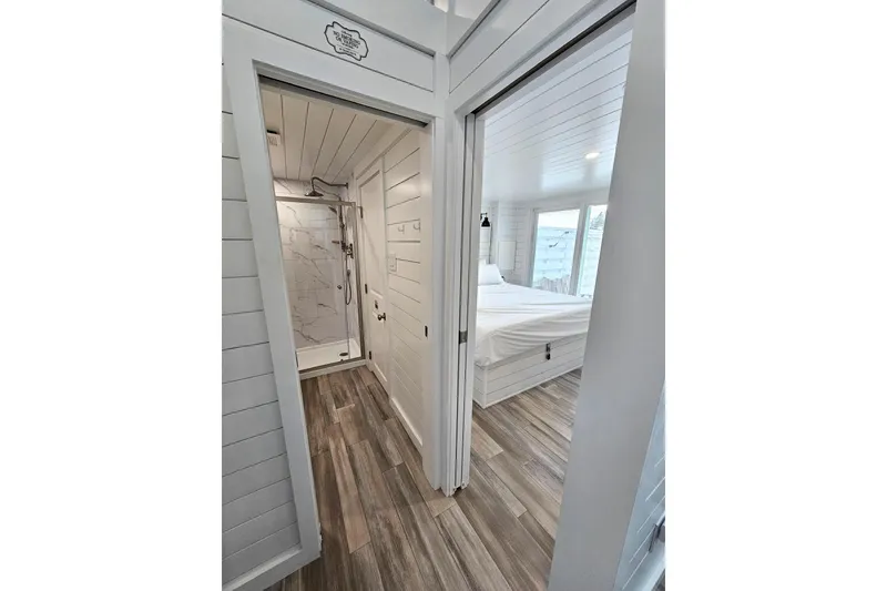 Slide: The Image of Modern 2025 houseboat interior with wood flooring, white walls, and a cozy bedroom. - 9