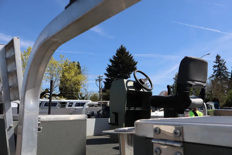 Slide: The Image of 2020 Ag Dryer Laker Pontoon boat with steering wheel and seat under clear blue sky. - 5