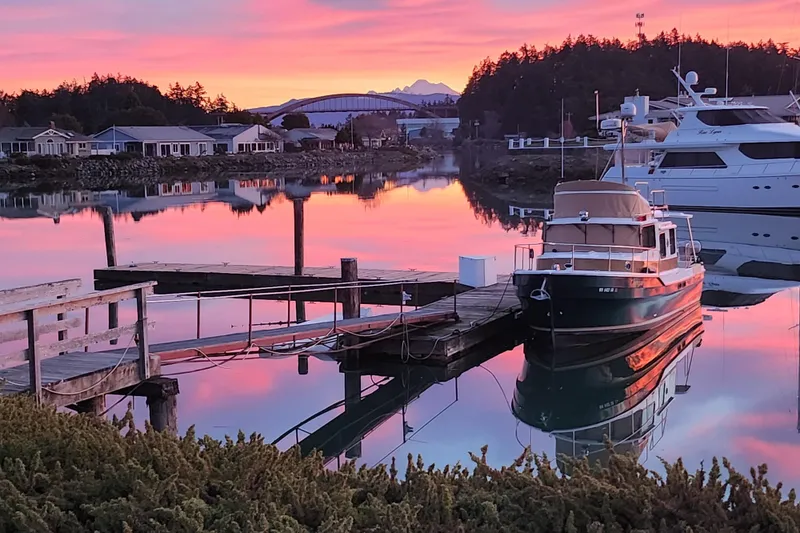 The Image of 2019 Ranger Tugs R-31 CB docked at sunset, reflecting on calm water. - 0