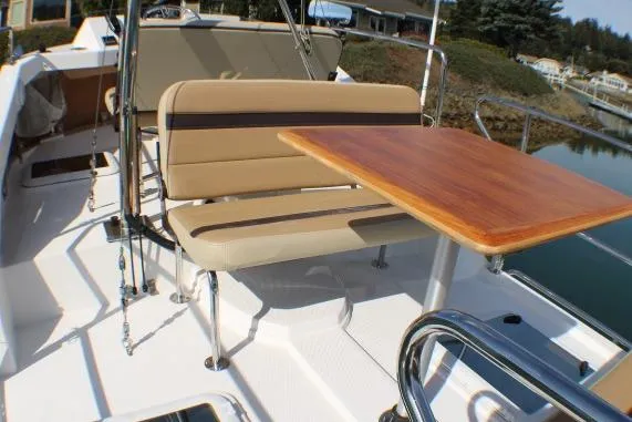 Slide: The Image of 2019 Ranger Tugs R-31 CB boat deck with seating and wooden table. - 12