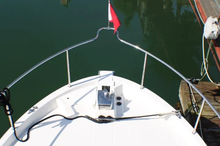 Slide: The Image of Bow view of 2019 Ranger Tugs R-31 CB boat with railing and flag. - 13