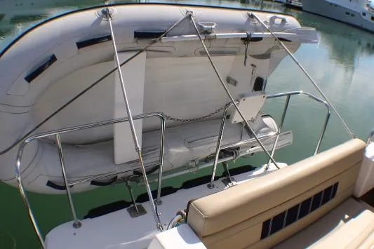 Slide: The Image of 2019 Ranger Tugs R-31 CB with mounted dinghy on the stern, docked in calm waters. - 16