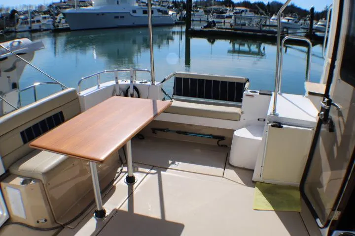 Slide: The Image of 2019 Ranger Tugs R-31 CB boat deck with seating and table, docked in marina. - 18