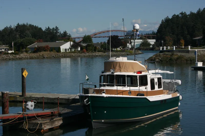 Slide: The Image of 2019 Ranger Tugs R-31 CB docked in a serene marina setting. - 3