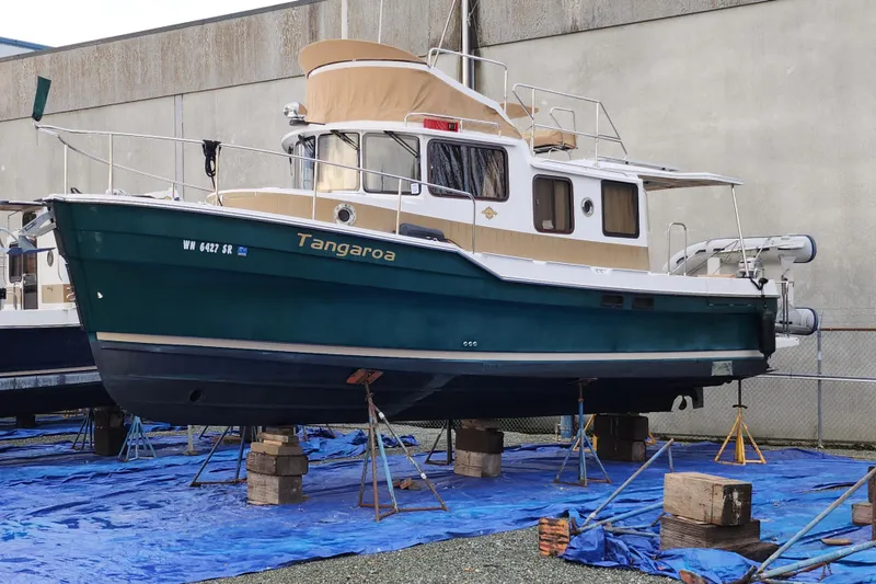 Slide: The Image of 2019 Ranger Tugs R-31 CB boat on stands, covered with blue tarps. - 4