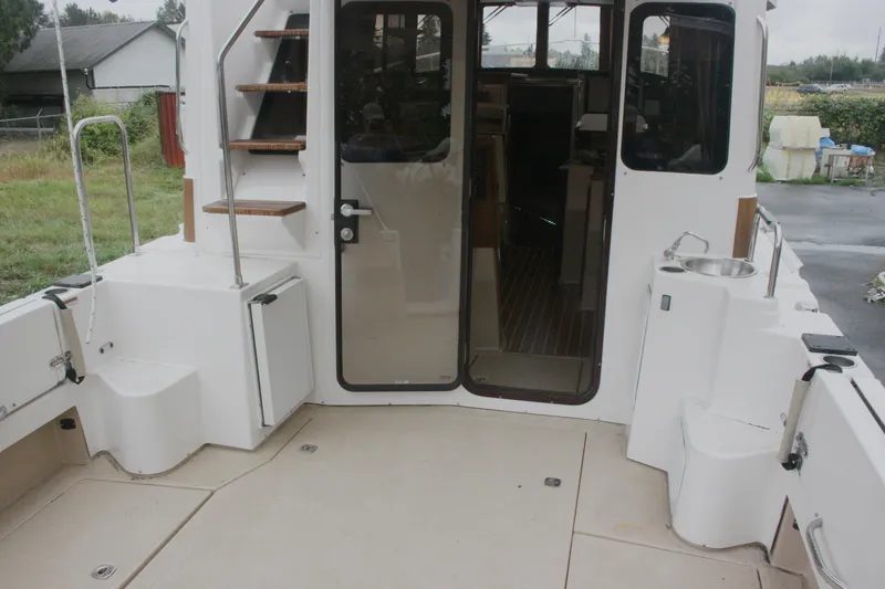 Slide: The Image of 2019 Ranger Tugs R-31 CB boat deck with stairs and door to cabin. - 41
