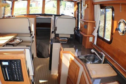 Slide: The Image of Interior of 2019 Ranger Tugs R-31 CB, featuring wood finishes and compact kitchen area. - 42