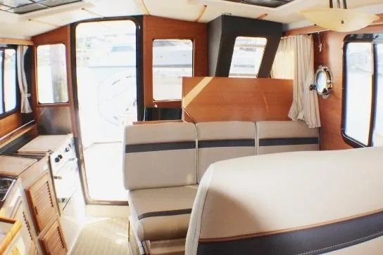 Slide: The Image of Interior of 2019 Ranger Tugs R-31 CB, featuring seating and windows. - 52