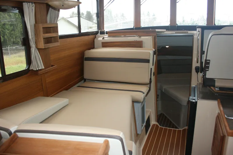 Slide: The Image of Interior of 2019 Ranger Tugs R-31 CB, featuring cozy seating and wood accents. - 55