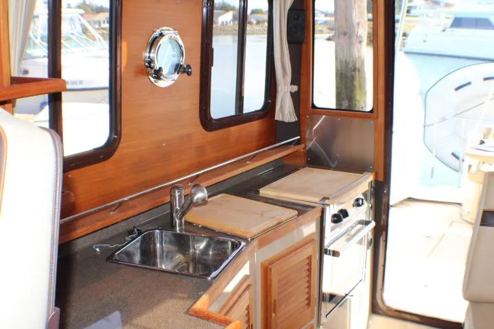Slide: The Image of 2019 Ranger Tugs R-31 CB interior kitchen with sink, stove, and wooden cabinetry. - 57