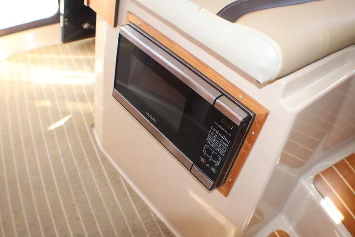 Slide: The Image of 2019 Ranger Tugs R-31 CB interior with built-in microwave and beige seating. - 62