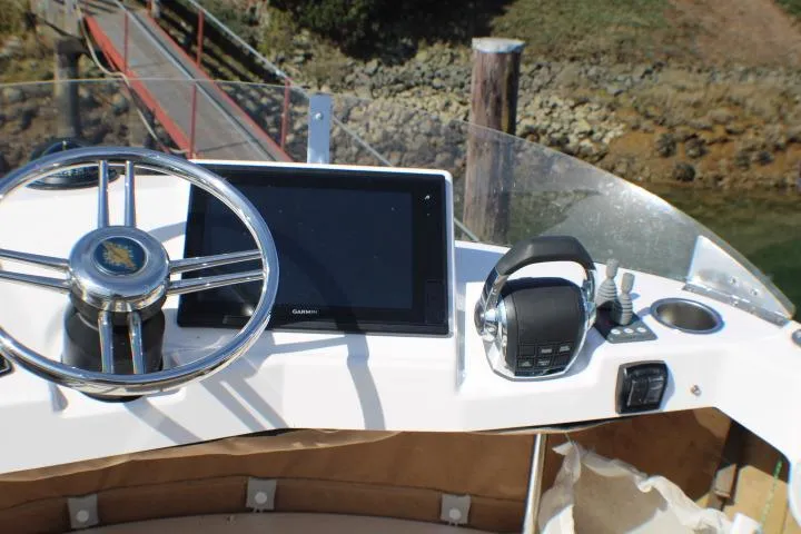 Slide: The Image of Cockpit of 2019 Ranger Tugs R-31 CB with steering wheel and navigation system. - 8