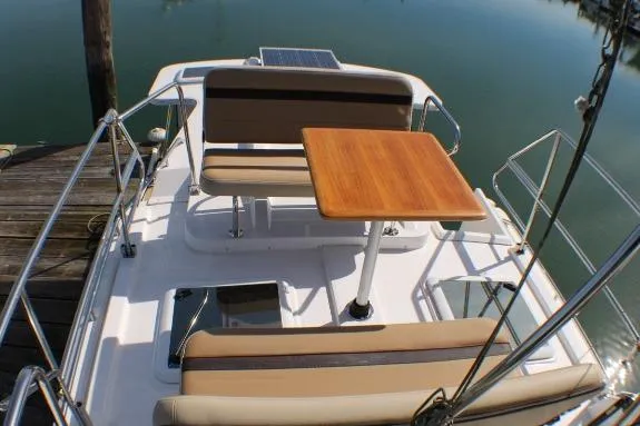 Slide: The Image of 2019 Ranger Tugs R-31 CB boat deck with seating and wooden table. - 9