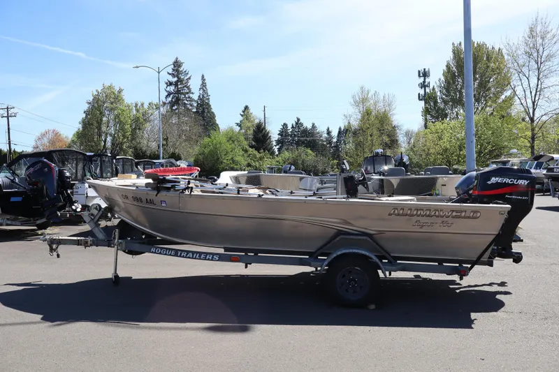 The Image of 2002 Alumaweld SUPER VEE LS boat on trailer, parked outdoors with trees in background. - 1