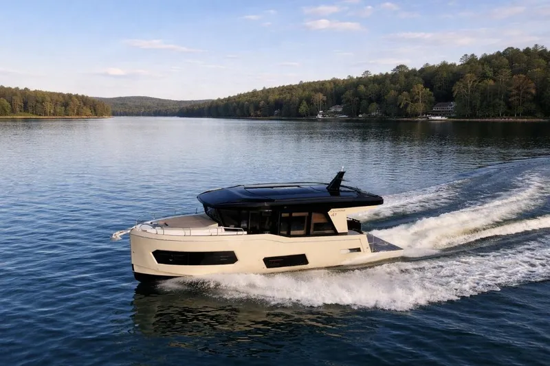 Slide: The Image of 2026 Cobra Yachts Campione 41 Coupe cruising on a serene lake with forested shoreline. - 4
