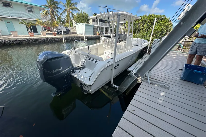 Slide: The Image of 2018 Sea Hunt Ultra 234 boat docked with Yamaha engine, in a scenic canal setting. - 10