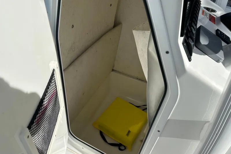 Slide: The Image of Storage compartment of 2018 Sea Hunt Ultra 234 boat with yellow bag inside. - 16