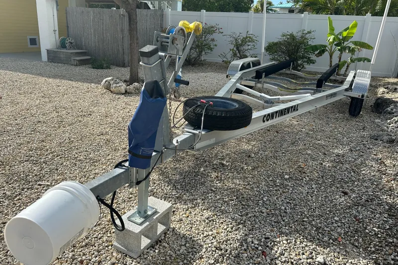 Slide: The Image of Boat trailer for 2018 Sea Hunt Ultra 234 on gravel driveway. - 19