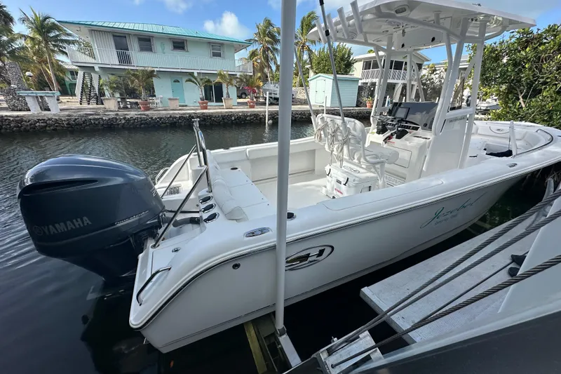 Slide: The Image of 2018 Sea Hunt Ultra 234 boat docked with Yamaha engine, tropical setting. - 8