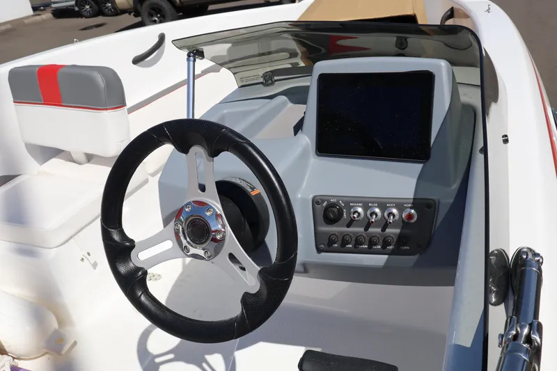 Slide: The Image of 2023 White River Tahoe boat dashboard with steering wheel and control panel. - 11
