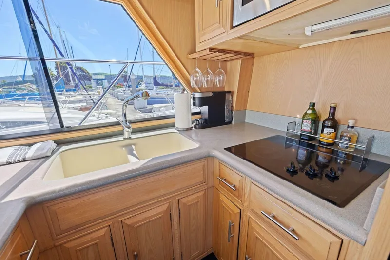 Slide: The Image of 1991 Ocean Alexander 520 Pilothouse kitchen with sink, stove, and marina view. - 17
