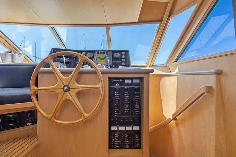 Slide: The Image of Pilothouse interior of 1991 Ocean Alexander 520, featuring wooden steering wheel and control panel. - 20