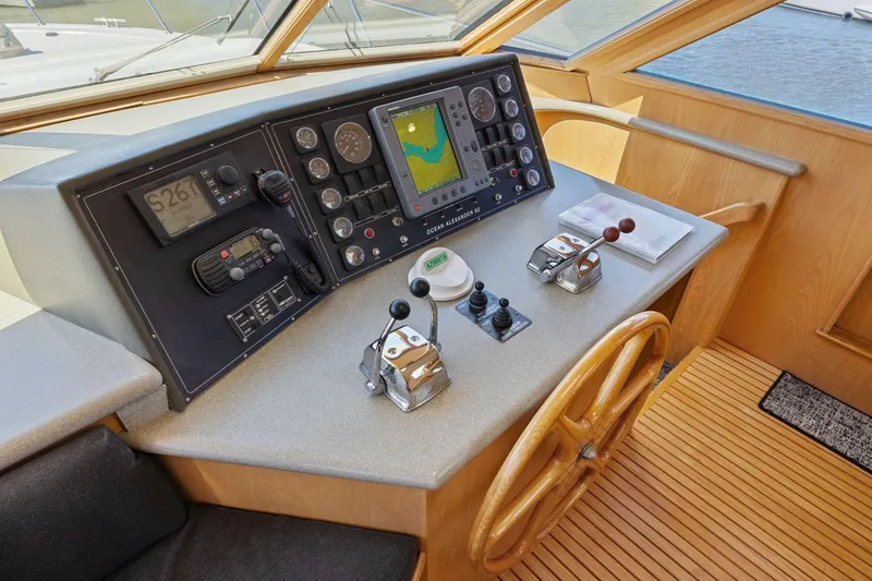 Slide: The Image of Pilothouse of 1991 Ocean Alexander 520, featuring navigation controls and wooden steering wheel. - 22