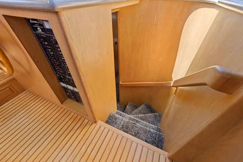 Slide: The Image of Staircase with wooden paneling and carpeted steps on a 1991 Ocean Alexander 520 Pilothouse. - 25