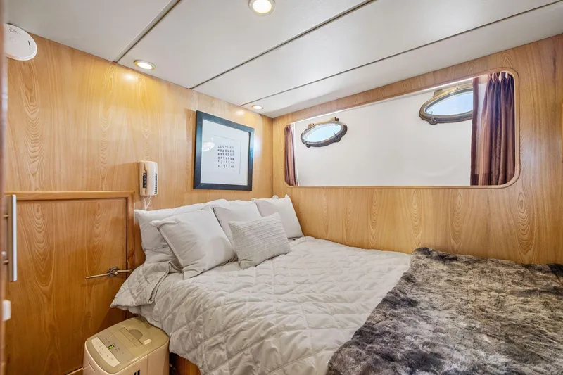Slide: The Image of Cozy bedroom in 1991 Ocean Alexander 520 Pilothouse yacht with wood paneling and porthole windows. - 32