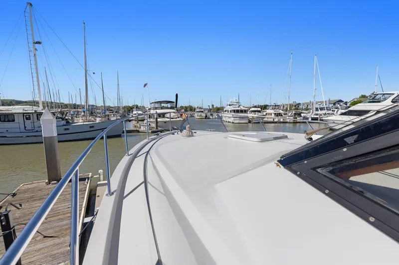 Slide: The Image of Ocean Alexander 520 Pilothouse yacht docked at marina, surrounded by sailboats, clear blue sky. - 40