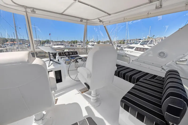 Slide: The Image of 1991 Ocean Alexander 520 Pilothouse interior with helm, seating, and marina view. - 42