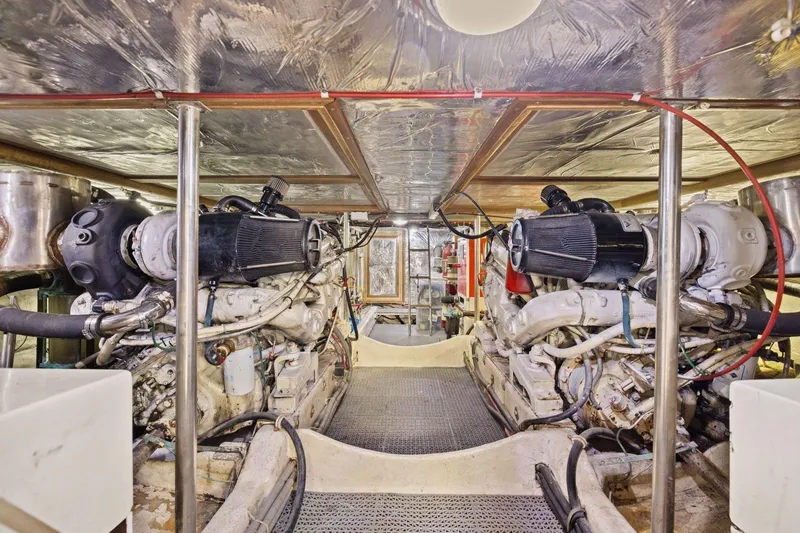 Slide: The Image of Engine room of 1991 Ocean Alexander 520 Pilothouse yacht, showcasing dual engines and mechanical systems. - 52