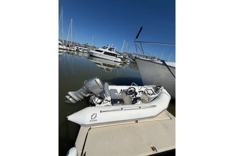 Slide: The Image of Inflatable Zodiac boat with Honda motor docked near Ocean Alexander 520 Pilothouse, 1991 model. - 60