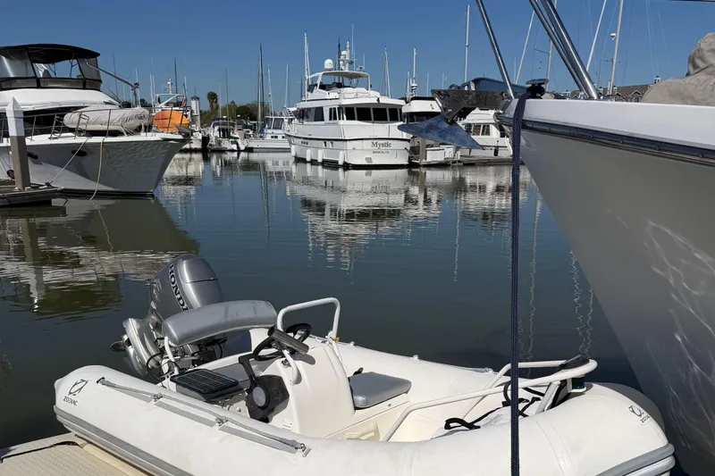 Slide: The Image of Docked Ocean Alexander 520 Pilothouse yacht, 1991 model, with inflatable boat in marina. - 61