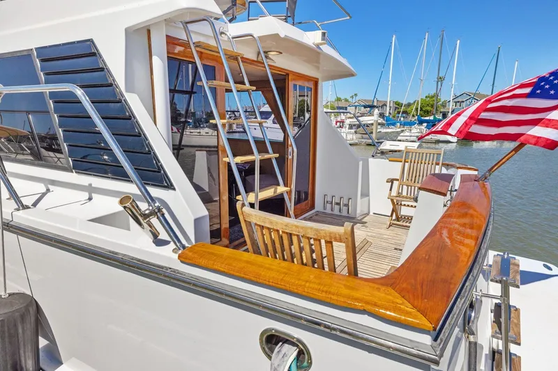 Slide: The Image of 1991 Ocean Alexander 520 Pilothouse yacht with American flag, docked in marina. - 7