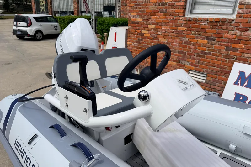 Slide: The Image of 2023 Highfield Classic 380 FCT boat with steering console, parked near brick wall. - 10