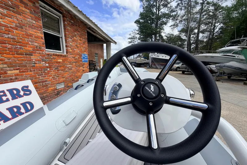Slide: The Image of Steering wheel of 2023 Highfield Classic 380 FCT boat, docked near brick building. - 14