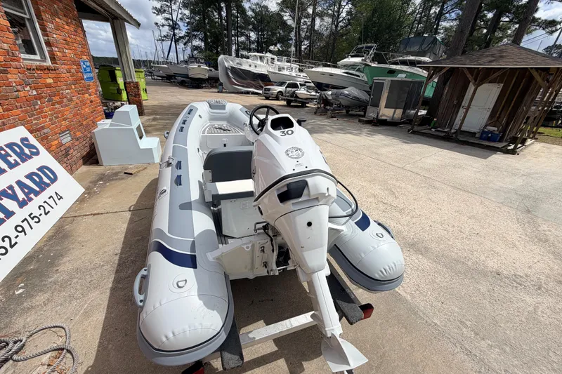 Slide: The Image of 2023 Highfield Classic 380 FCT inflatable boat with outboard motor in a boatyard. - 7