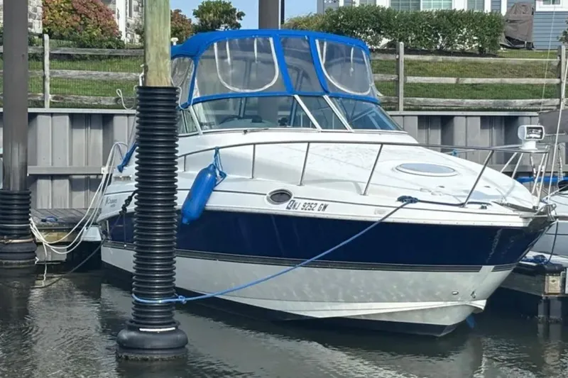 The Image of 2005 Cruisers Yachts 280 CXi Express docked, featuring blue canopy and sleek design. - 1