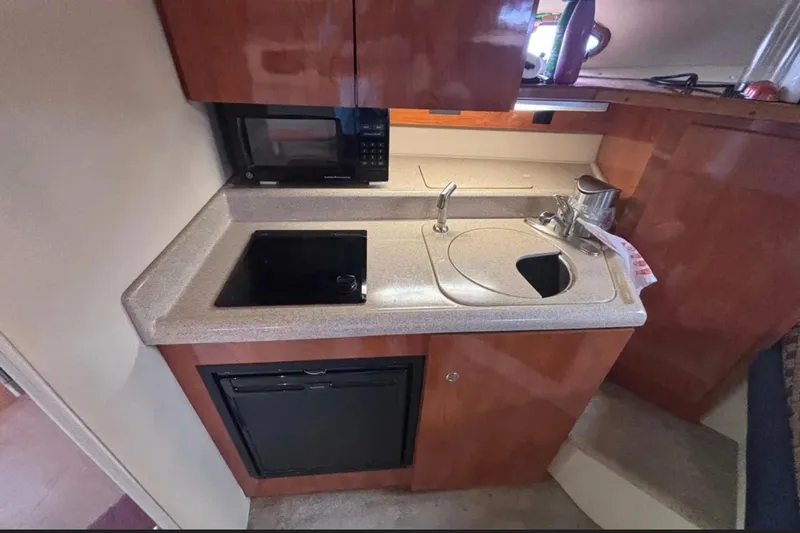 Slide: The Image of 2005 Cruisers Yachts 280 CXi Express kitchen with sink, stove, and microwave. - 10