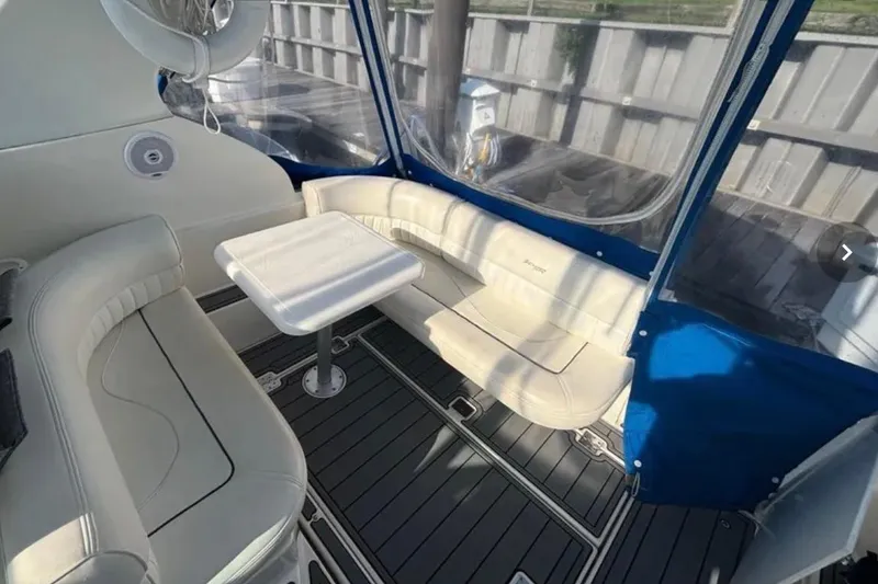 Slide: The Image of 2005 Cruisers Yachts 280 CXi Express interior with seating and table, featuring blue accents. - 5