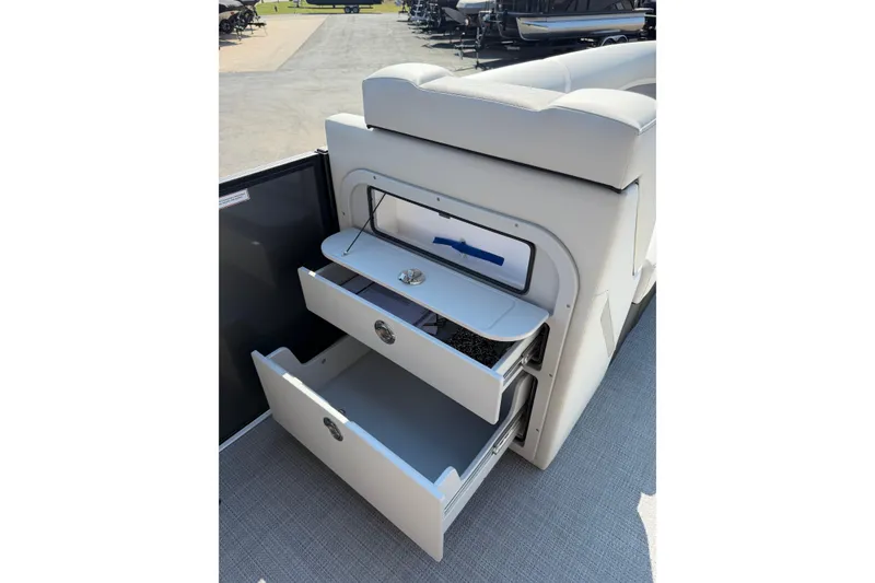 Slide: The Image of 2026 Crest Conquest 250 SLSC boat interior storage compartments with open drawers. - 20