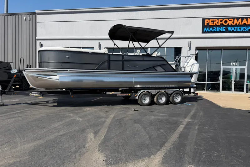 Slide: The Image of 2026 Crest Conquest 250 SLSC pontoon boat on trailer outside marine dealership. - 3