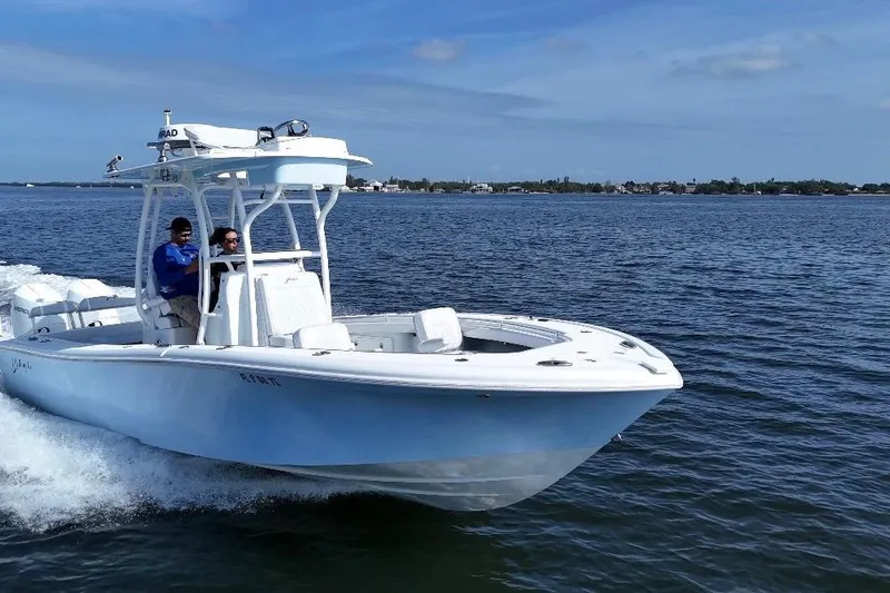 Slide: The Image of 2023 Yellowfin 26 Hybrid boat cruising on open water under clear blue skies. - 11