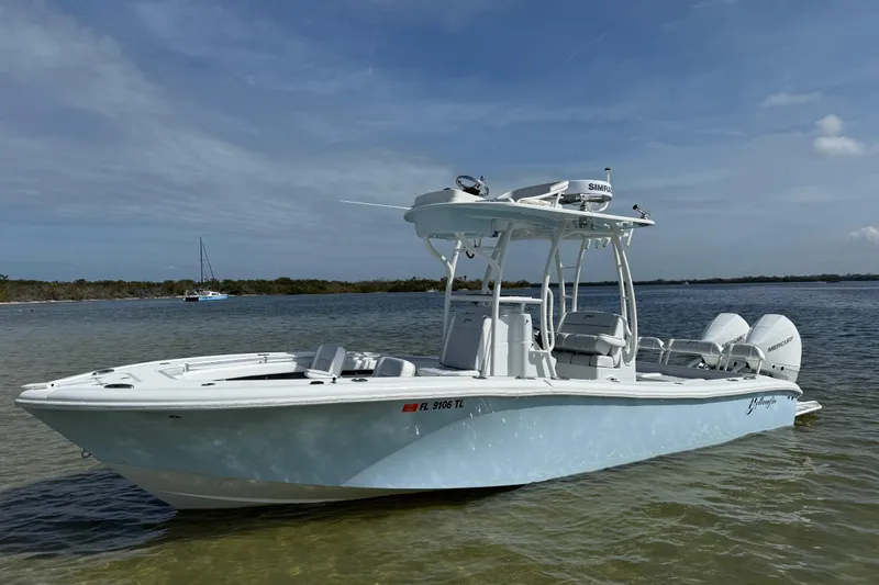 Slide: The Image of 2023 Yellowfin 26 Hybrid boat in shallow water, showcasing sleek design and dual engines. - 13