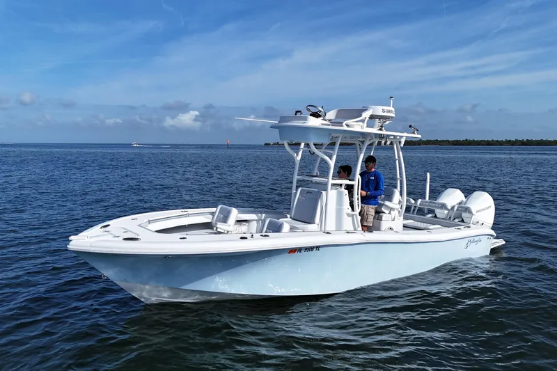 Slide: The Image of 2023 Yellowfin 26 Hybrid boat on calm ocean waters under clear blue sky. - 2