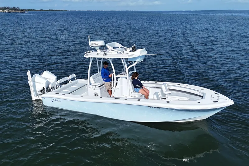 Slide: The Image of 2023 Yellowfin 26 Hybrid boat cruising on open water with two passengers. - 3