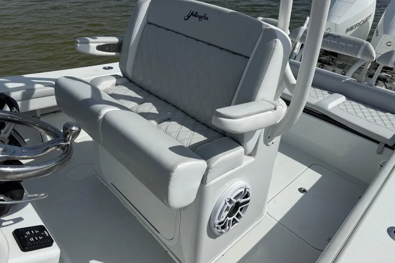 Slide: The Image of 2023 Yellowfin 26 Hybrid boat interior with cushioned seating and steering wheel. - 32